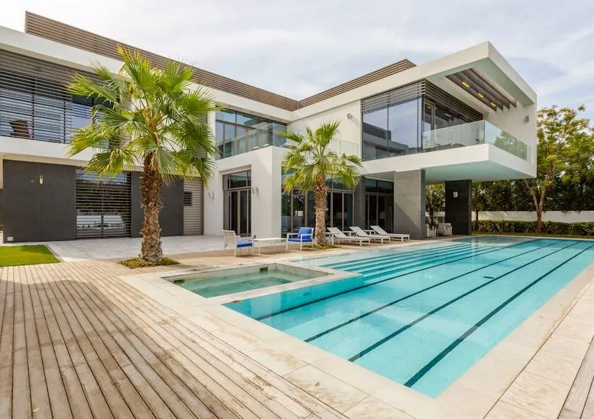 Explore this luxurious modern villa in Dubai with a stunning swimming pool and palm trees.