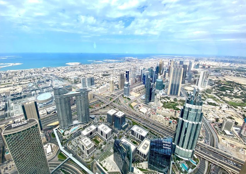 Stunning aerial view of Dubai's skyline, featuring skyscrapers and the sea.