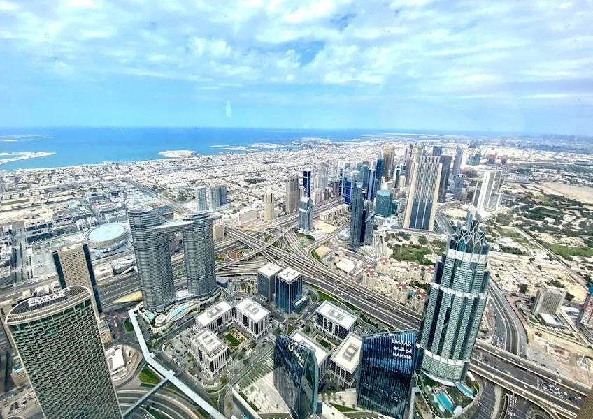 Stunning aerial view of Dubai's skyline, featuring skyscrapers and the sea.