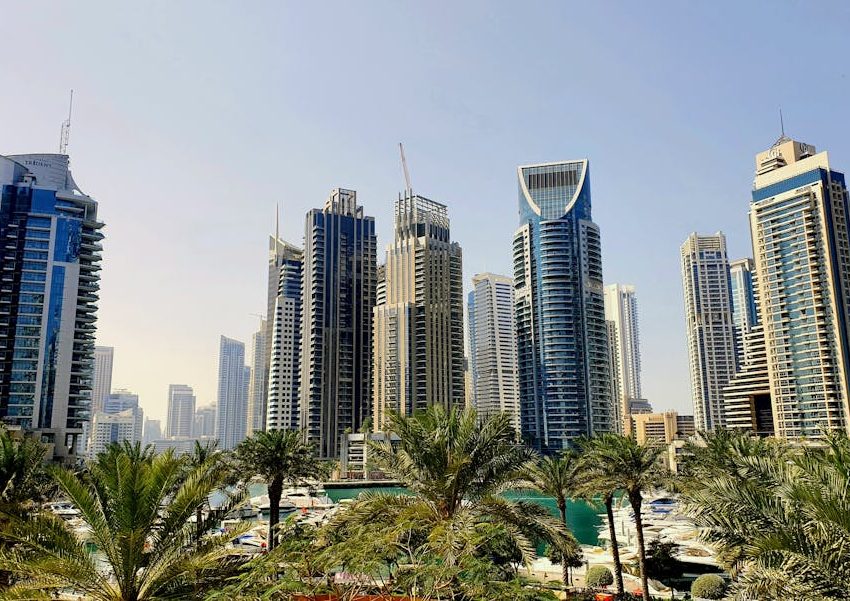 A vibrant view of Dubai's skyline featuring modern skyscrapers and palm trees during the day.